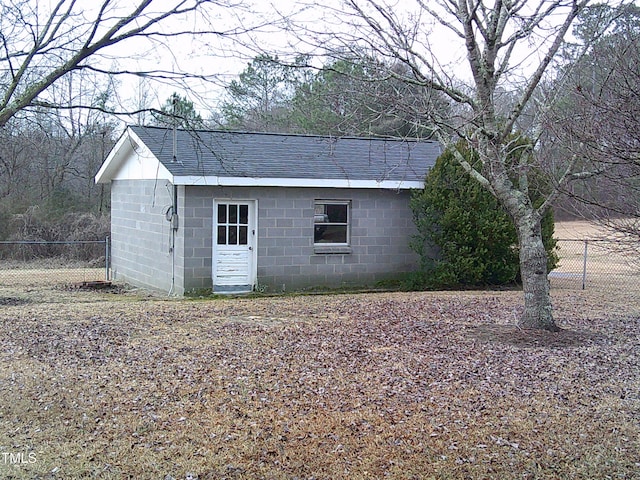 view of outbuilding featuring fence and an outbuilding