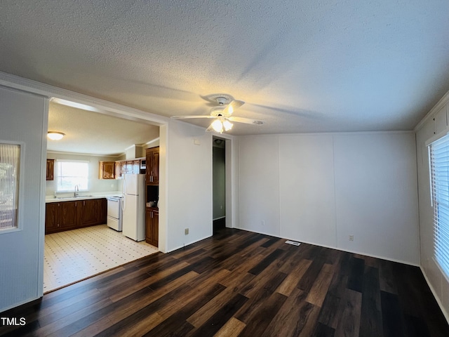 unfurnished living room with light wood-style floors, ceiling fan, a textured ceiling, and a sink