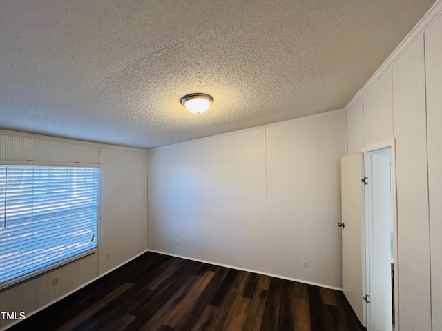 unfurnished room featuring dark wood finished floors and a textured ceiling