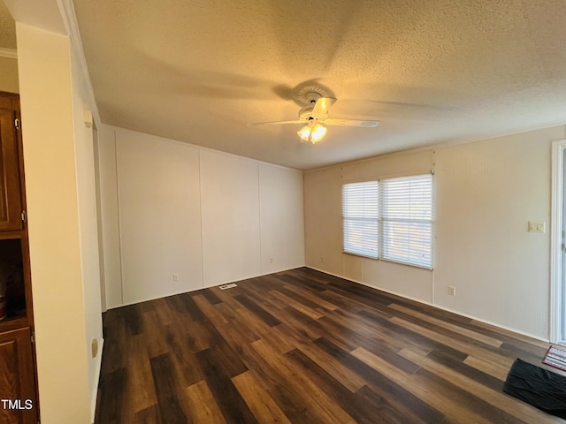 unfurnished room with a textured ceiling, dark wood-style flooring, and a ceiling fan