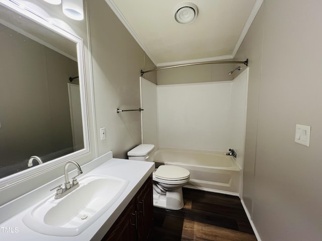 bathroom featuring bathtub / shower combination, toilet, wood finished floors, vanity, and ornamental molding