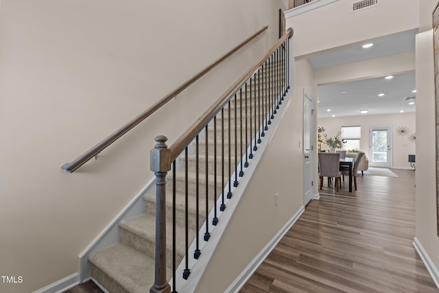 staircase featuring recessed lighting, wood finished floors, visible vents, and baseboards