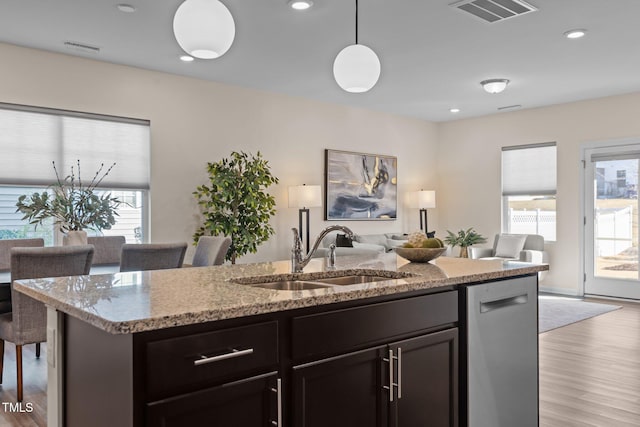 kitchen with a sink, visible vents, a healthy amount of sunlight, open floor plan, and dishwasher