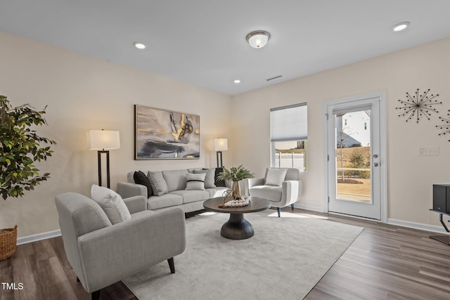 living area featuring recessed lighting, baseboards, and wood finished floors