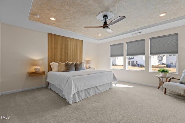 bedroom featuring carpet floors, a raised ceiling, visible vents, and baseboards