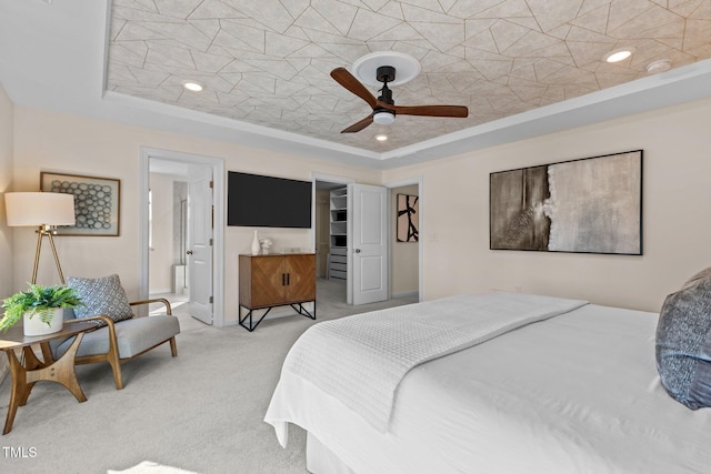 bedroom with a tray ceiling, light carpet, and recessed lighting