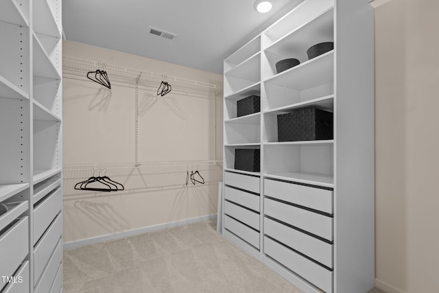 walk in closet with visible vents and light colored carpet