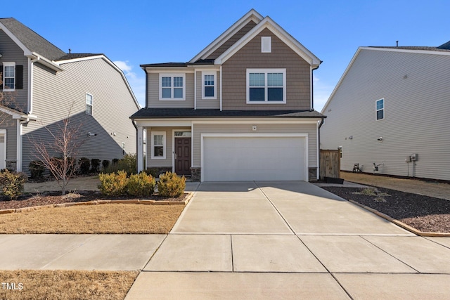 craftsman-style house featuring stone siding, driveway, and an attached garage