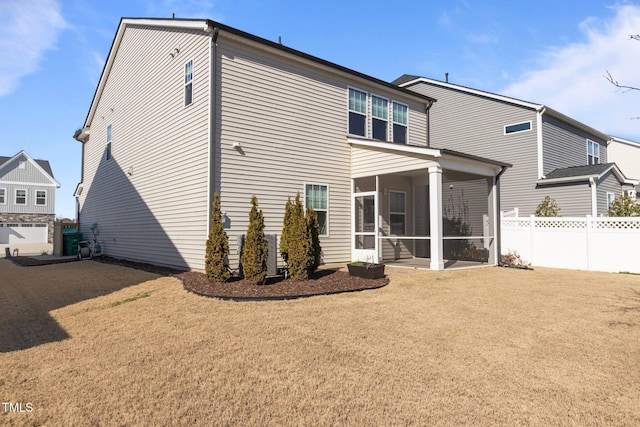 back of property featuring a sunroom, fence, and a lawn