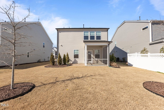 back of house with a sunroom, fence, and a lawn