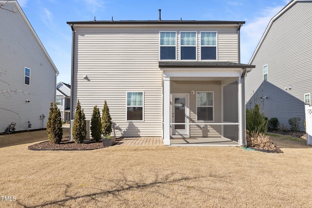 rear view of house with a sunroom and a yard