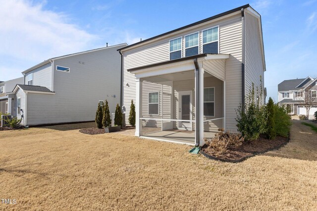 rear view of property with a sunroom and a lawn