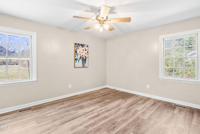 unfurnished room with baseboards, visible vents, light wood finished floors, and ceiling fan