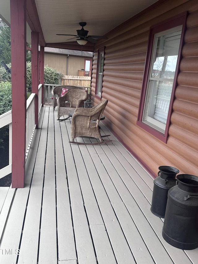 wooden terrace with covered porch and a ceiling fan