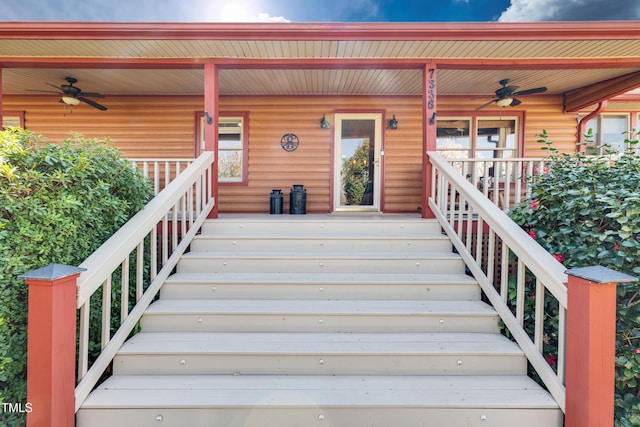 wooden terrace with stairs, covered porch, and a ceiling fan