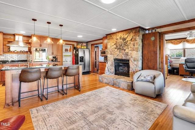 living area with a stone fireplace and light wood-style floors