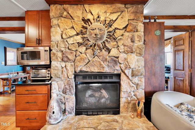 kitchen featuring a toaster, a stone fireplace, and brown cabinets