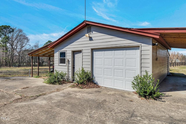 garage with driveway and fence