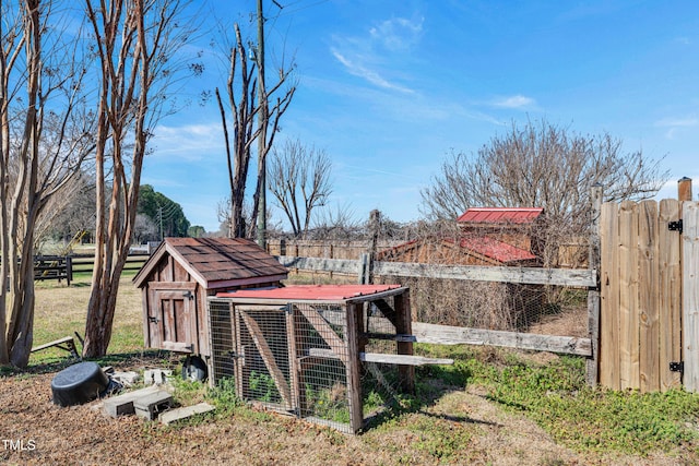 view of yard featuring an outdoor structure, exterior structure, and fence