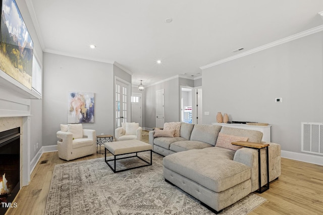 living room featuring baseboards, a fireplace, visible vents, and wood finished floors