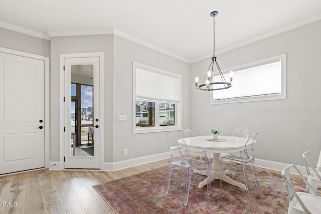 dining space featuring baseboards, light wood-style flooring, and crown molding