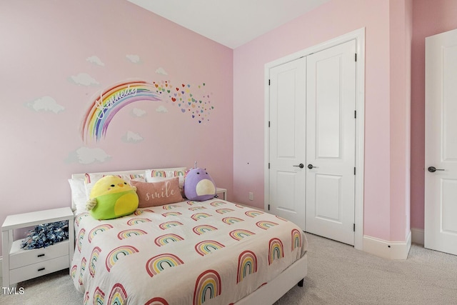 carpeted bedroom featuring baseboards and a closet