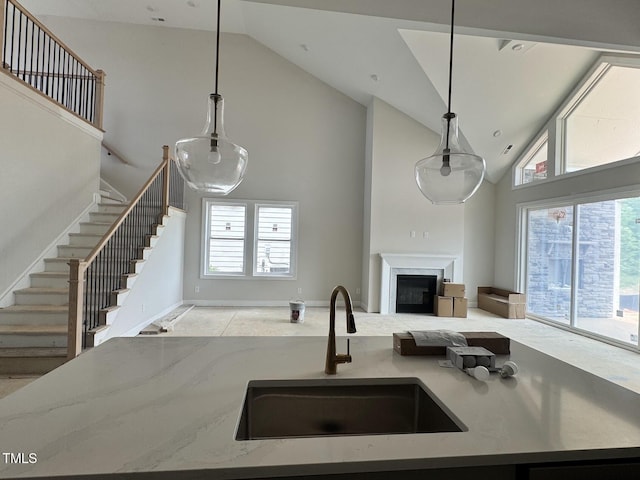 63 Daybreak Way, Fuquay Varina, NC 27526 - kitchen with high vaulted ceiling, a sink, open floor plan, light stone countertops, and a fireplace