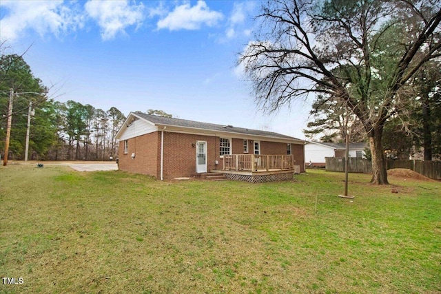 back of house with a yard, fence, a deck, and brick siding