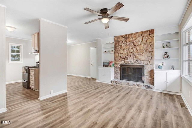 unfurnished living room featuring light wood finished floors, a fireplace, built in features, and crown molding