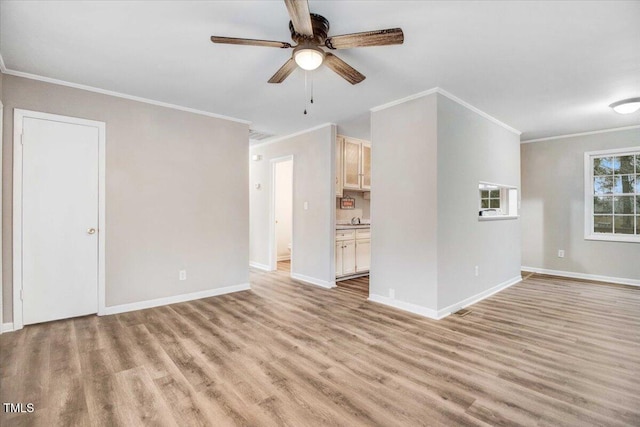 unfurnished living room with baseboards, ceiling fan, ornamental molding, and light wood-style floors