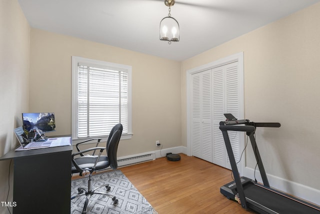 office featuring light wood-type flooring, baseboards, and a baseboard heating unit