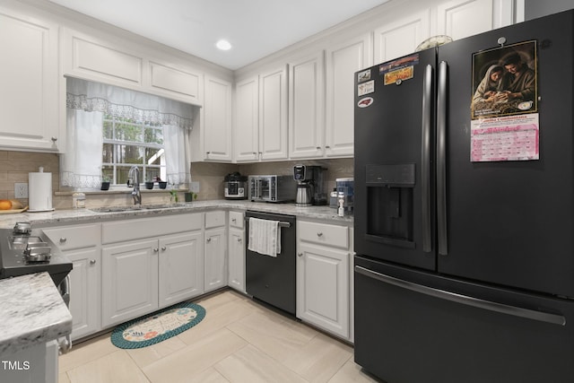 kitchen with black refrigerator with ice dispenser, backsplash, white cabinetry, a sink, and dishwashing machine