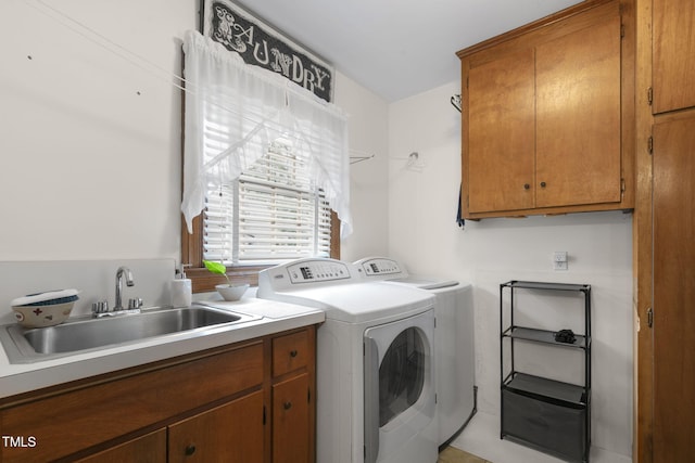 laundry room with cabinet space, a sink, and separate washer and dryer