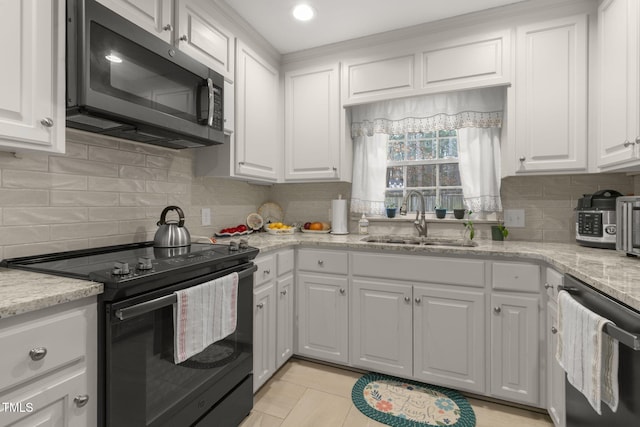 kitchen featuring black / electric stove, a sink, white cabinetry, dishwasher, and stainless steel microwave