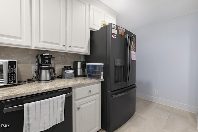 kitchen featuring white cabinets, backsplash, baseboards, and black fridge