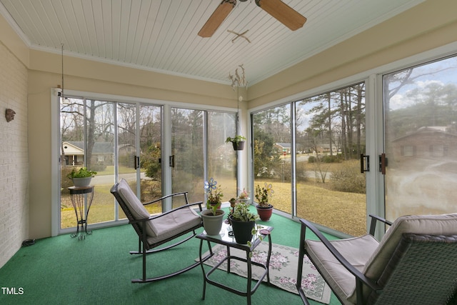 sunroom featuring a ceiling fan and wood ceiling