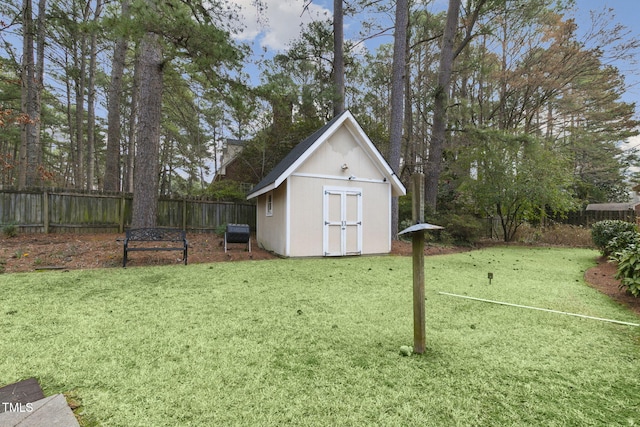 view of yard with an outbuilding, a fenced backyard, and a storage shed