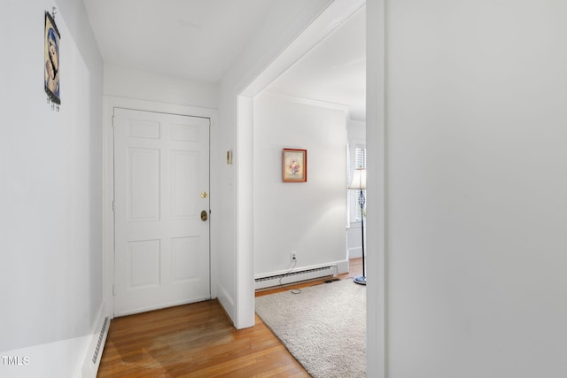 entryway featuring a baseboard heating unit, baseboard heating, light wood-style flooring, and baseboards