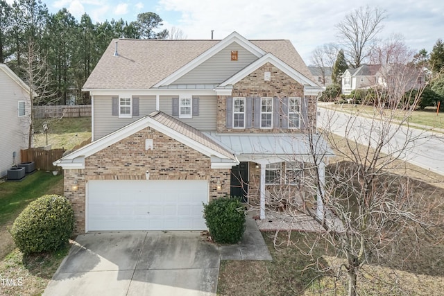 view of front of house with driveway, brick siding, roof with shingles, and fence