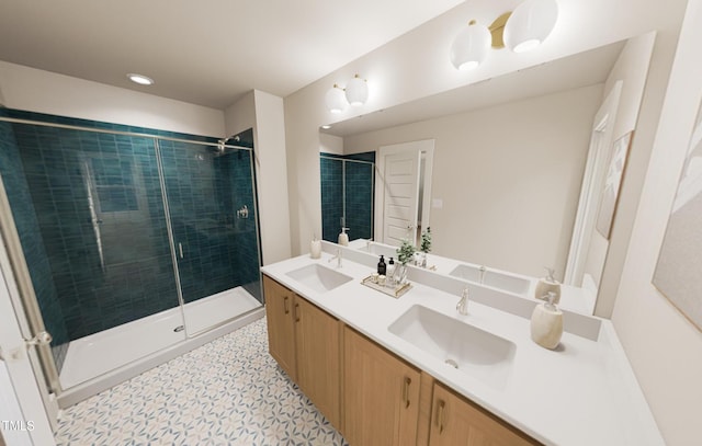 full bathroom featuring double vanity, a shower stall, and a sink