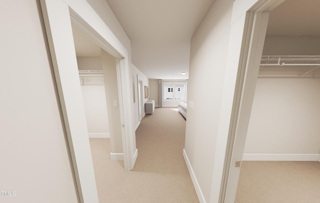 hallway featuring carpet flooring and baseboards