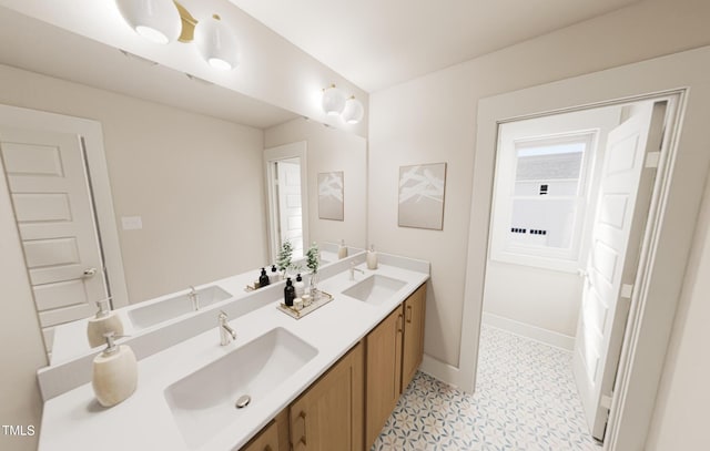 bathroom with a sink, baseboards, and double vanity