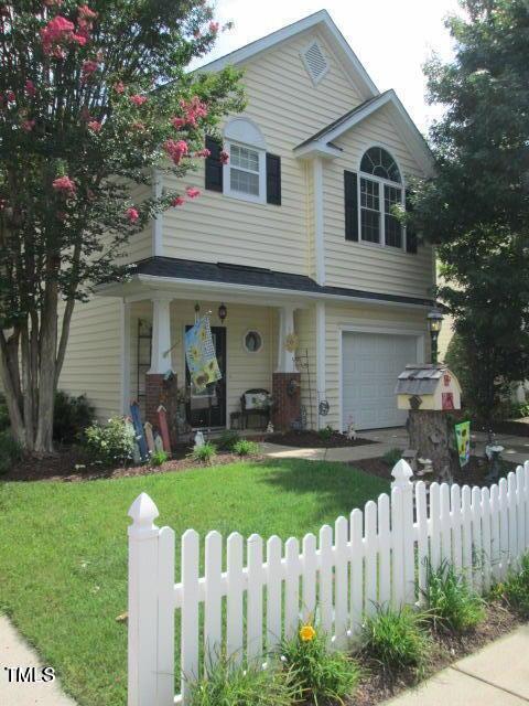 view of front of house with a fenced front yard, an attached garage, and a front lawn