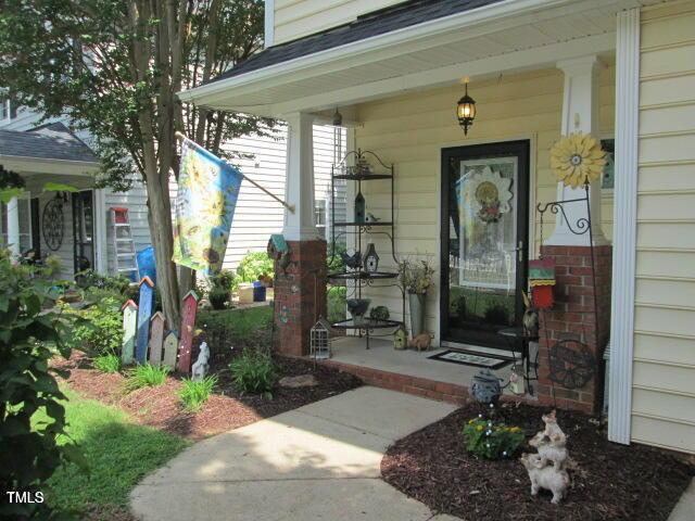 view of exterior entry with a porch and brick siding