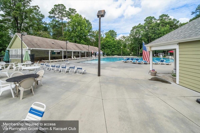 community pool with a patio and fence