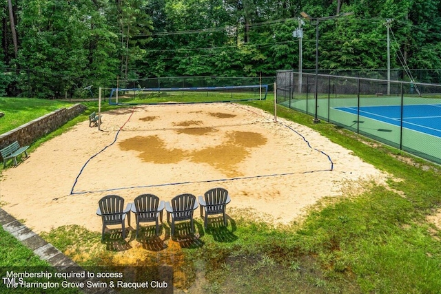 view of home's community with volleyball court and fence