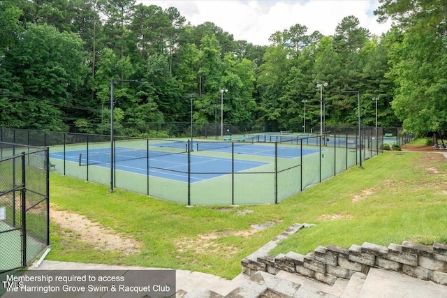 view of tennis court featuring a yard and fence