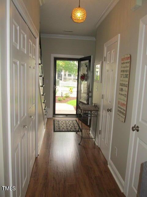 entryway featuring crown molding, wood finished floors, and baseboards