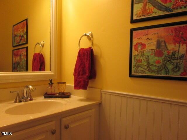 bathroom with a wainscoted wall and vanity