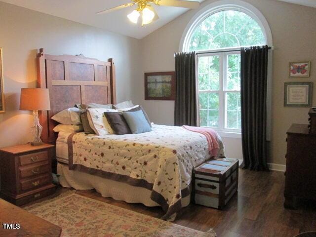 bedroom with ceiling fan, wood finished floors, and vaulted ceiling